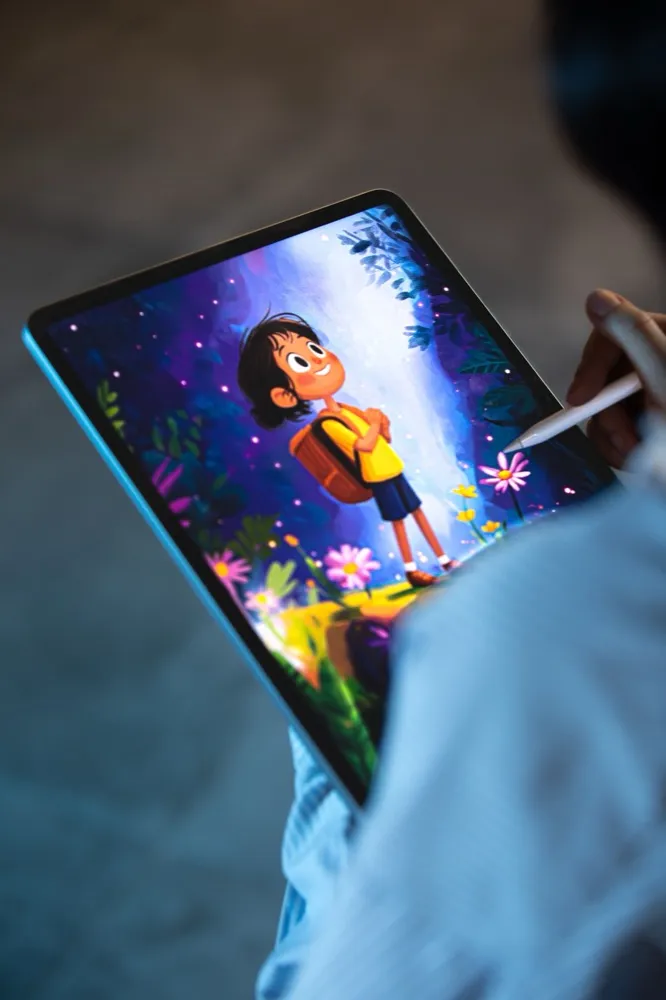 Illustrator sketching a hand-painted character on a tablet for a mascot visual identity project